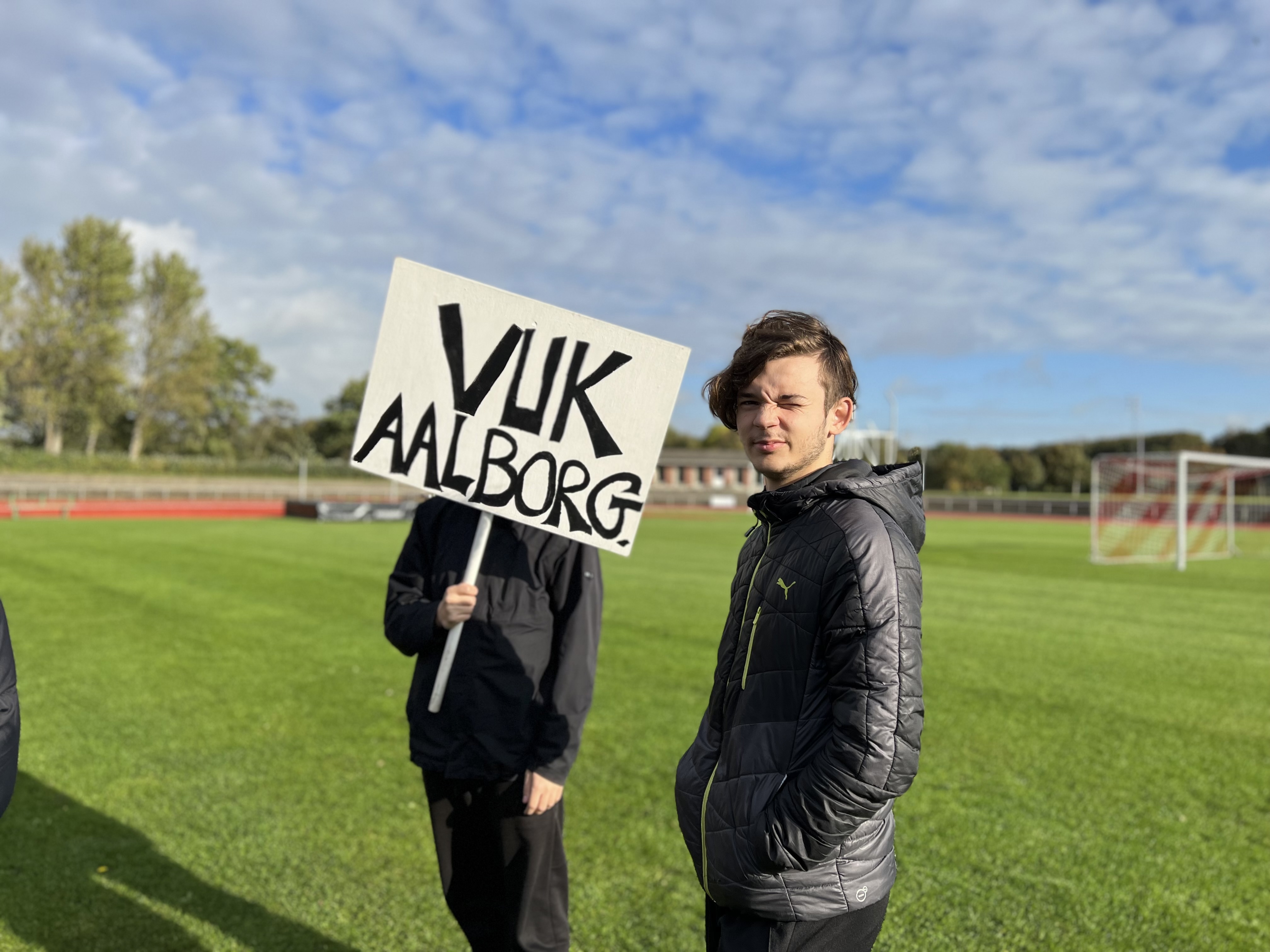 Unge står med skilt med VUK Aalborg