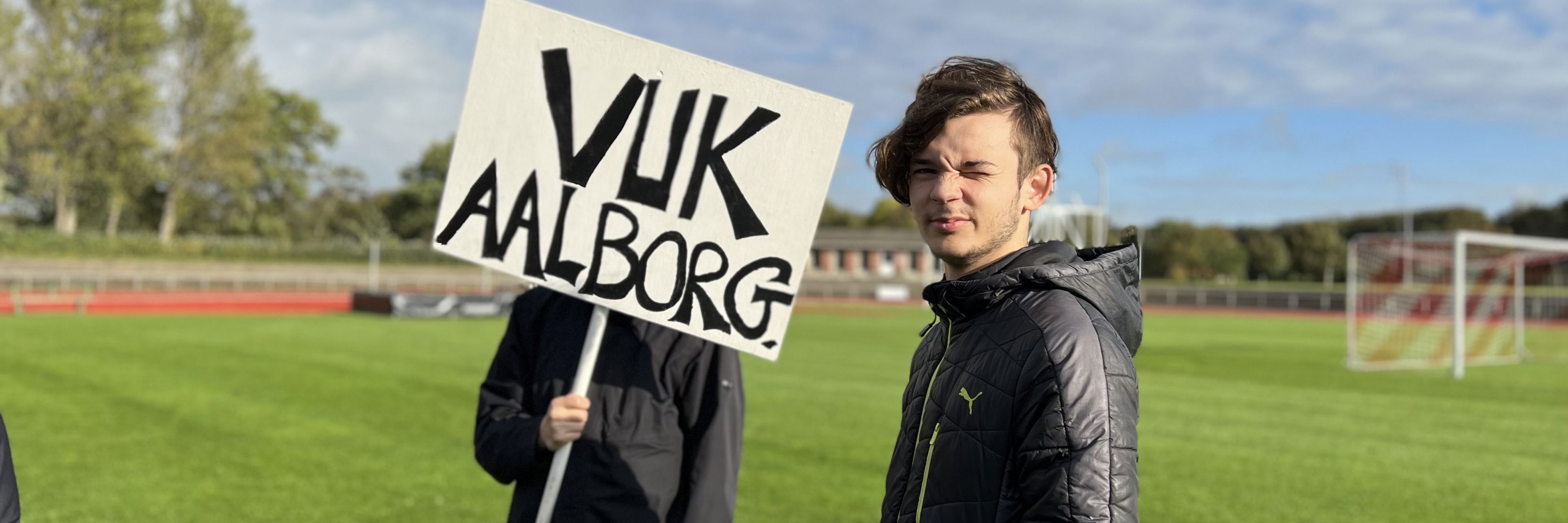 Unge står med skilt med VUK Aalborg