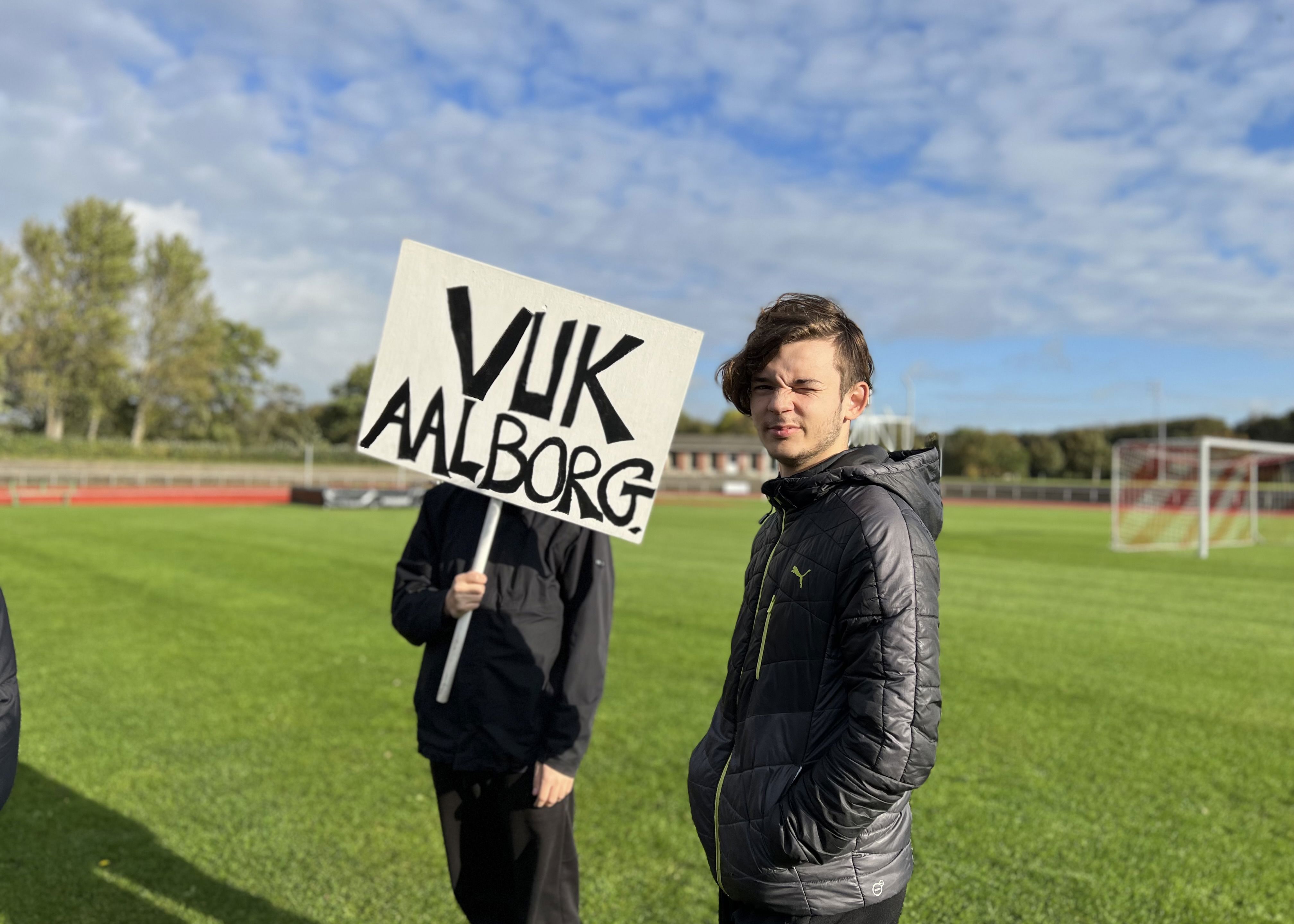 Unge står med skilt med VUK Aalborg